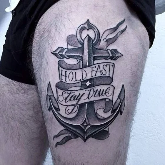 Traditional black and grey anchor with quote tattoo design for men on thigh