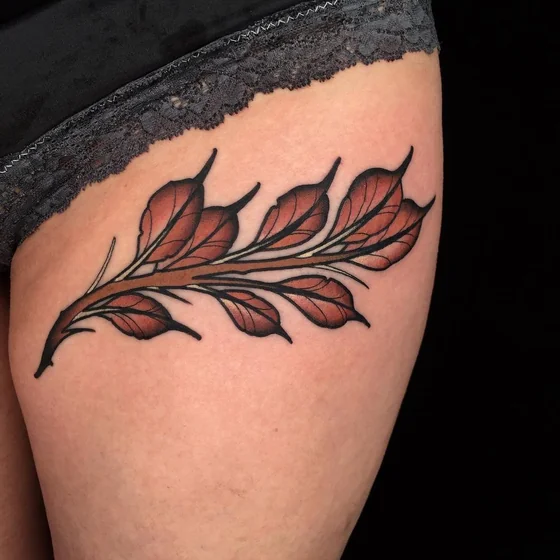 Traditional floral vine tattoo design for women on thigh.