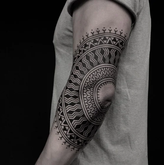 Tribal Geometric pattern tattoo idea for men on elbow and upper arm