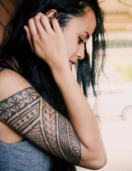 Tribal geometric half sleeve tattoo for women on upper arm.