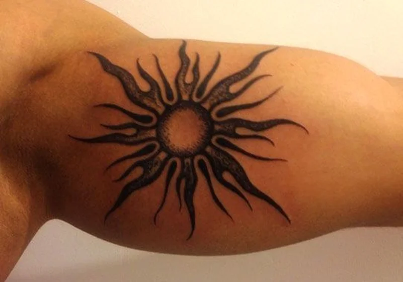 Tribal sun blackwork tattoo design for men on upper arm