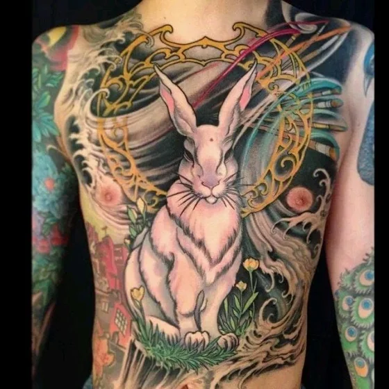 Vibrant Japanese Neo-Traditional rabbit, floral, and peacock tattoo design for men on back and shoulder