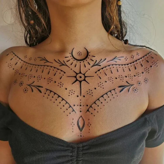 Women's tribal dotwork sun and moon tattoo design on chest.