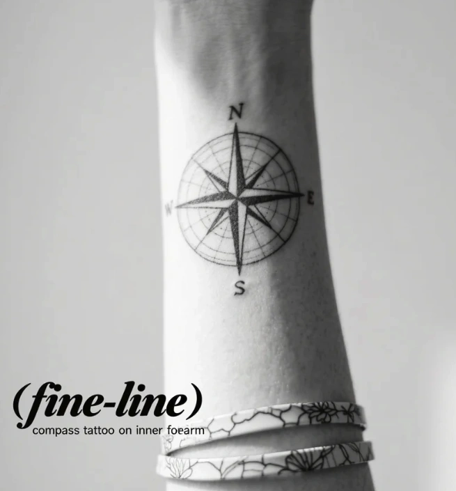 fine-line compass tattoo on inner forearm symbolizing direction and personal journey